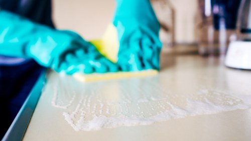 Professional cleaner sanitizing an Airbnb bathroom in [Location]